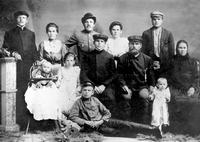 1910 — 1911 (написано рукой Ю. А. Шестаковой). Семья Шестаковых на Дальнем Востоке после встречи с земляками Ивана Ильича и Марии. Слева (сидят) еще холостой Николай Иванович, рядом — его отец, наш дед Иван Ильич (в кепке), около него — бабушка. Меж ними девочка стоит. Это Нюра. На полу, распростершись полулежа, запечатлен Саня. В верхнем ряду (стоят) слева: Алексей Иванович, старший сын Шестаковых, рядом с ним — его жена Клавдия Ивановна и первая их дочь Ниночка. Рядом — Лида. За ее спиной Пресников (в шляпе), Татьяна и дальний родственник Иван Иванович Шестаков. Фотография сделана в г. Никольск-Уссурийске.